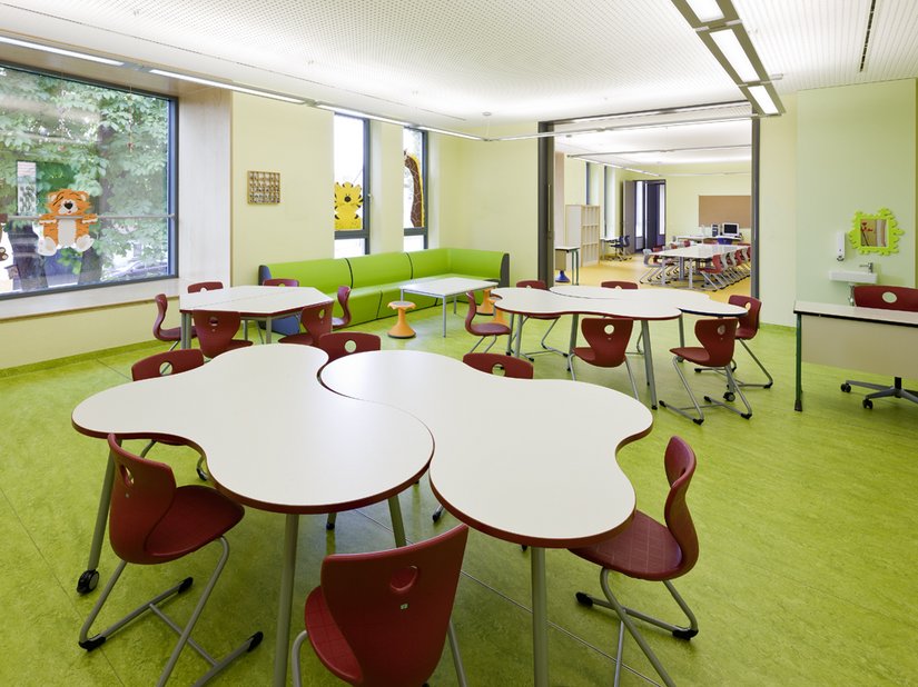 Pomieszczenia klasowe są zdominowane przez intensywne odcienie zieleni i czerwieni. Geometria ławek zapewnia elastyczność podczas lekcji.