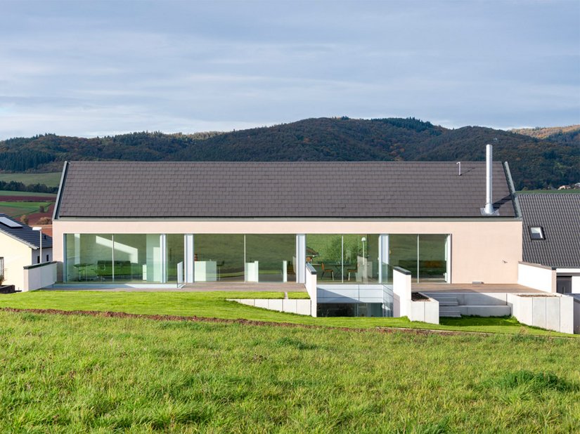 Ten wybudowany w 2019 roku dom zaskakuje elegancką, prostą kubaturą, a dodatkowo wykorzystuje naturalną topografię terenu.
Zdjęcie: ©Johannes Marburg, Genewa