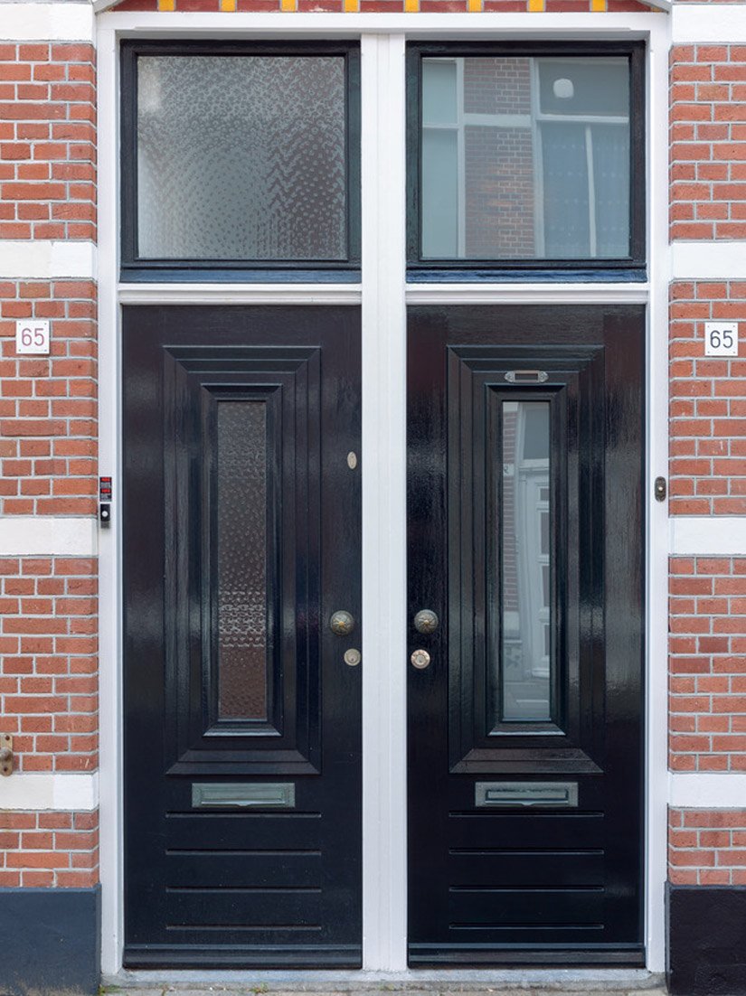 Elementy drzwi i okien pokryte czarnym połyskliwym lakierem przełamują kompozycję elewacji.