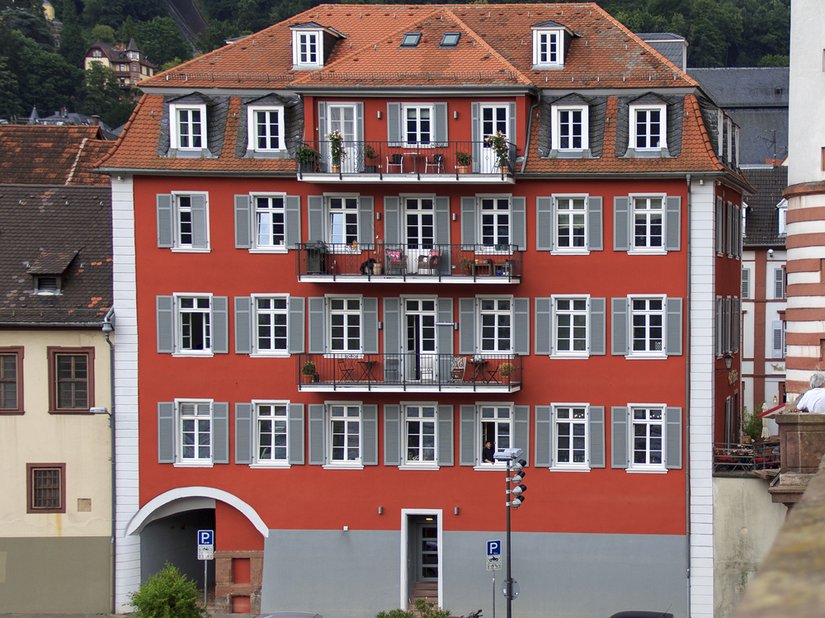 Elewacja tego starego budynku szkolnego jest zdominowana przez kolory czerwony i szary.